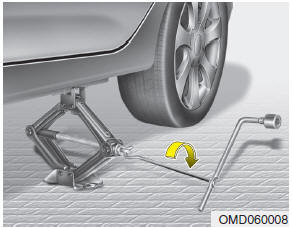 8. Insert the jack handle into the jack and turn it clockwise, raising the vehicle